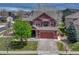 Charming two-story home with a brick garage, manicured lawn, and mature trees at 22965 Allendale Ave, Parker, CO 80138
