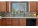 Kitchen sink with cabinets, view to the backyard, and a mosaic tile backsplash at 22965 Allendale Ave, Parker, CO 80138