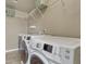 Well-equipped laundry room with modern washer and dryer, ample counter space, and storage shelves at 22965 Allendale Ave, Parker, CO 80138
