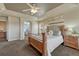 Bright main bedroom showcasing a decorative headboard, tray ceiling, and an open doorway to an en-suite bathroom at 22965 Allendale Ave, Parker, CO 80138