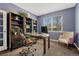 This home office features custom built-in shelves, a large window, and comfortable seating for a productive workspace at 22965 Allendale Ave, Parker, CO 80138