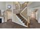 Grand foyer showcasing a carpeted staircase with decorative wrought iron spindles and natural wood banister at 22965 Allendale Ave, Parker, CO 80138