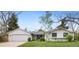 Charming home featuring a two-car garage, lush lawn, and mature trees at 5965 S Gaylord Way, Greenwood Village, CO 80121
