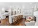 Open kitchen with white cabinets, quartz counters, island seating, and hardwood flooring at 5965 S Gaylord Way, Greenwood Village, CO 80121