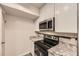 Updated kitchen with stainless steel range and microwave at 2880 S Locust St # 704N, Denver, CO 80222