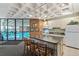 Modern kitchen with white appliances, kitchen island, bar seating, and an adjacent indoor pool view at 2880 S Locust St # 704N, Denver, CO 80222