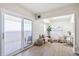 Sunlit office space featuring a modern workspace, a stylish rug, and a door leading to a private balcony at 2880 S Locust St # 704N, Denver, CO 80222