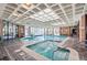 Indoor swimming pool and jacuzzi with skylights, brick walls, and multiple seating options at 2880 S Locust St # 704N, Denver, CO 80222