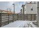 Cozy fenced backyard with light snow coverage near modern residential building at 2804 W 53Rd Ave, Denver, CO 80221