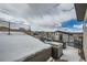 Rooftop deck with snow-covered furniture and railings with city views and cloudy skies in background at 2804 W 53Rd Ave, Denver, CO 80221