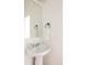 Bathroom featuring a pedestal sink, chrome fixtures, and a decorative mirror at 2680 Blake St # 12, Denver, CO 80205