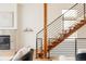 Bright living room featuring modern wooden stairs, a fireplace, and neutral décor at 2680 Blake St # 12, Denver, CO 80205