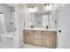 Double vanity bathroom features wood cabinets, modern lighting, and a shower/tub combination at 11269 Star Streak Rd, Littleton, CO 80125