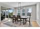 Bright dining room features modern chandelier, wood table with seating for four, and sliding doors to the outside patio at 11269 Star Streak Rd, Littleton, CO 80125
