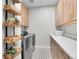 A stylish laundry room with shelving, a washer and dryer, and light cabinets at 11269 Star Streak Rd, Littleton, CO 80125