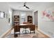Stylish home office featuring a large wood desk, built-in bookshelves, and ample natural light at 11269 Star Streak Rd, Littleton, CO 80125