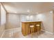Basement bar featuring a wooden counter, stools, sink, microwave, and neutral carpet at 1470 S Quebec Way # 46, Denver, CO 80231