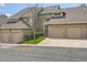Townhome with brick and tan siding, individual garages, and landscaped front yard at 1470 S Quebec Way # 46, Denver, CO 80231