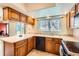 Well-lit kitchen area with tile flooring, ample countertop space, and natural wood cabinetry at 1470 S Quebec Way # 46, Denver, CO 80231