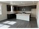 Modern kitchen showcasing dark wood cabinetry, a large island with white countertops, and stainless steel appliances at 16654 W 93Rd Way, Arvada, CO 80007