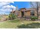 Stunning home featuring stone accents, a manicured lawn, and beautiful landscaping at 7850 Vallagio Ln, Englewood, CO 80112