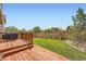 Well-maintained backyard with wooden deck, green lawn, and stone accent wall at 24416 E Powers Ave, Aurora, CO 80016