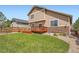 Spacious backyard with a wooden deck, lawn, and landscaped surroundings at 24416 E Powers Ave, Aurora, CO 80016