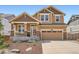 Charming two-story home featuring a covered front porch, stone accents, and a two-car garage at 24416 E Powers Ave, Aurora, CO 80016
