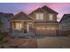 Charming two-story home featuring a covered front porch, stone accents, and a two-car garage at 24416 E Powers Ave, Aurora, CO 80016