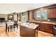 Kitchen with stainless steel sink, wooden cabinets, island, and a dining table in view at 24416 E Powers Ave, Aurora, CO 80016