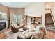 Open concept living room seamlessly connects to the kitchen and staircase, with a cozy fireplace feature at 24416 E Powers Ave, Aurora, CO 80016