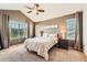 Comfortable main bedroom boasts carpet flooring, a ceiling fan, and ample natural light at 24416 E Powers Ave, Aurora, CO 80016