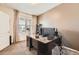 Bright office features a large desk, window, and neutral carpet, creating an ideal work-from-home space at 24416 E Powers Ave, Aurora, CO 80016