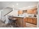 Custom bar area with rich wood cabinets, quartz countertop, seating, and wine storage at 4121 S Allison St, Denver, CO 80235