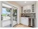 Bar area featuring custom cabinetry with a wine rack, beverage cooler, and access to the outdoor patio at 4121 S Allison St, Denver, CO 80235