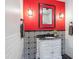 Quirky bathroom with bright red walls, black and white accents, and stylish vanity at 4121 S Allison St, Denver, CO 80235