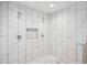 Modern tiled shower with dual shower heads, granite bench, and custom shelving niche at 4121 S Allison St, Denver, CO 80235