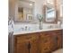 Bathroom featuring double vanity, tile floors, large mirrors and updated fixtures at 4121 S Allison St, Denver, CO 80235