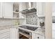 Gourmet kitchen featuring stainless steel appliances, granite counters, mosaic backsplash, and custom white cabinetry at 4121 S Allison St, Denver, CO 80235