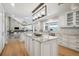 Open kitchen design boasts a large island, white cabinetry, and mountain views from the window over the sink at 4121 S Allison St, Denver, CO 80235