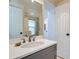 Bathroom featuring gray vanity with white sink and countertop, and large mirror at 912 S Galena St, Aurora, CO 80247