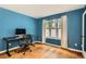 Bedroom with blue walls, hardwood floors, large window, modern desk, and office chair at 912 S Galena St, Aurora, CO 80247