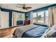 Bedroom featuring wood floors, blue walls, large windows, and a wooden dresser at 912 S Galena St, Aurora, CO 80247