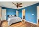 Bedroom with wood floors, blue walls, ceiling fan, and view to an ensuite bathroom at 912 S Galena St, Aurora, CO 80247