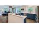 Bright kitchen with blue cabinets, stainless appliances, and a view to an adjacent living area and outdoor deck at 912 S Galena St, Aurora, CO 80247