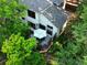 Aerial view of a home's rear exterior and a deck with an outdoor table surrounded by mature trees and lush landscaping at 912 S Galena St, Aurora, CO 80247