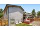 Exterior view of the home showcasing the wooden deck and a fenced backyard at 8432 S Upham Way, Littleton, CO 80128
