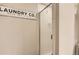 Stylish half bath with clear glass enclosed shower and modern laundry signage at 8432 S Upham Way, Littleton, CO 80128