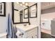 Charming bathroom features a vanity with dark framed mirror and fixtures at 8432 S Upham Way, Littleton, CO 80128