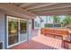 The covered wooden deck features built-in bench seating and a sliding door entry at 8432 S Upham Way, Littleton, CO 80128
